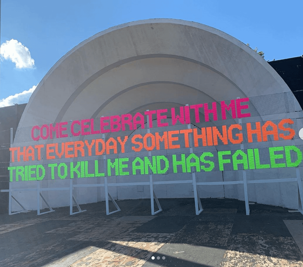 neon text reads: come celebrate with me that everyday something has tried to kill me and has failed
